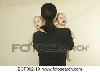 Stock Photograph - a mother holding 
her twin babies. 
fotosearch - search 
stock photos, 
pictures, images, 
and photo clipart