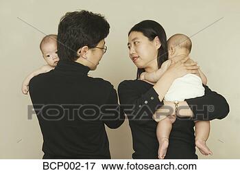 Foto - pais,  segurando, 
 seu,  gêmeo, 
 bebês. fotosearch 
- busca de fotos, 
imagens e clipart
