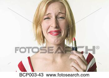 Stock Photo - a woman holding 
up the lipstick 
she's just applied. 
fotosearch - search 
stock photos, 
pictures, images, 
and photo clipart