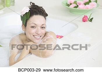 Stock Photograph - a woman smiling 
as she relaxes 
in a bathtub full 
of bubbles. fotosearch 
- search stock 
photos, pictures, 
images, and photo 
clipart