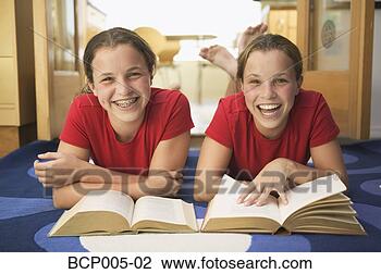 Stock Photo - twin teen girls 
smile while doing 
their homework. 
fotosearch - search 
stock photos, 
pictures, images, 
and photo clipart