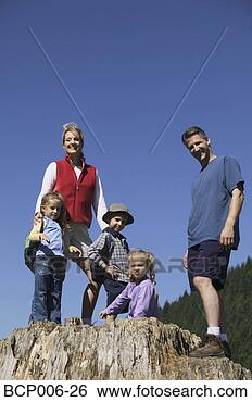 Stock Photo - family posing 
on a big tree 
stump. fotosearch 
- search stock 
photos, pictures, 
images, and photo 
clipart