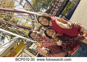 Stock Photography - parents and daughter 
eating at an amusement 
park. fotosearch 
- search stock 
photos, pictures, 
images, and photo 
clipart
