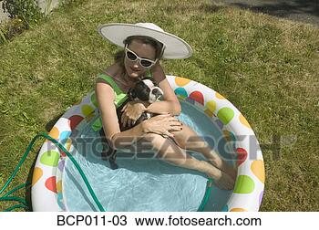 Stock Photo - woman sitting 
with her dog in 
backyard baby 
pool. fotosearch 
- search stock 
photos, pictures, 
images, and photo 
clipart