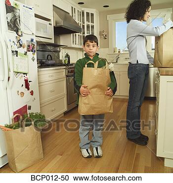 Stock Photography - mother and son 
unloading groceries 
in the kitchen. 
fotosearch - search 
stock photos, 
pictures, images, 
and photo clipart
