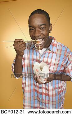 Stock Photography - teenage boy eating 
noodles from carton. 
fotosearch - search 
stock photos, 
pictures, images, 
and photo clipart