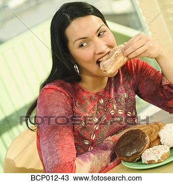 Stock Photo - young woman eating 
a doughnut. fotosearch 
- search stock 
photos, pictures, 
images, and photo 
clipart