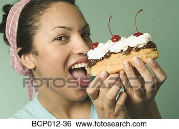 Stock Photo - young woman holding 
an eclair pastry. 
fotosearch - search 
stock photos, 
pictures, images, 
and photo clipart