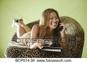 Stock Photo - a young woman 
shopping with 
her credit card 
over the telephone. 
fotosearch - search 
stock photos, 
pictures, images, 
and photo clipart