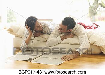 Stock Photo - a couple lounge 
in bed while reading 
the newspaper. 
fotosearch - search 
stock photos, 
pictures, images, 
and photo clipart