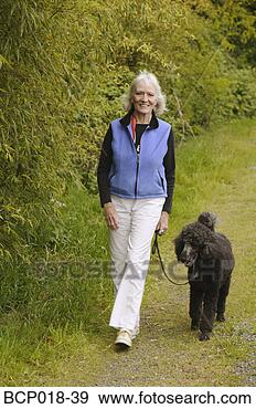 Stock Photograph - a woman walking 
her dog. fotosearch 
- search stock 
photos, pictures, 
images, and photo 
clipart