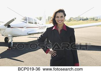 Stock Photo - young woman standing 
in front of her 
airplane. fotosearch 
- search stock 
photos, pictures, 
images, and photo 
clipart