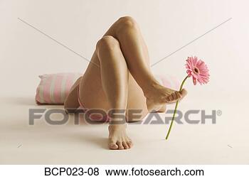 Stock Photo - woman lying down 
with a flower 
between her toes. 
fotosearch - search 
stock photos, 
pictures, images, 
and photo clipart