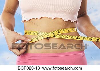 Stock Photo - a woman measuring 
her waist. fotosearch 
- search stock 
photos, pictures, 
images, and photo 
clipart