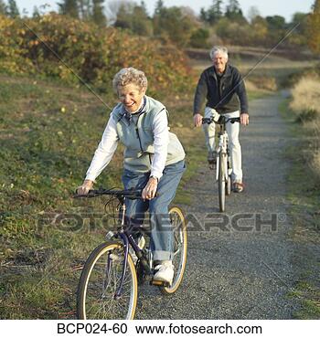 Stock Photography - senior couple 
riding bikes on 
a trail. fotosearch 
- search stock 
photos, pictures, 
images, and photo 
clipart