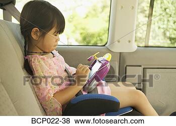 Stock Photo - a girl in her 
car seat playing 
with an electronic 
toy. fotosearch 
- search stock 
photos, pictures, 
images, and photo 
clipart