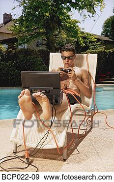 Stock Photograph - a teenaged boy 
playing video 
games poolside. 
fotosearch - search 
stock photos, 
pictures, images, 
and photo clipart