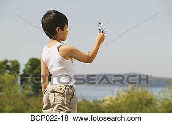 Stock Photo - young boy taking 
a photo with his 
mobile phone. 
fotosearch - search 
stock photos, 
pictures, images, 
and photo clipart