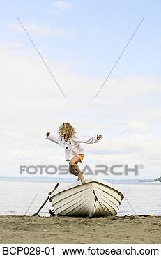 Stock Photography - little girl jumping 
off a beached 
boat. fotosearch 
- search stock 
photos, pictures, 
images, and photo 
clipart