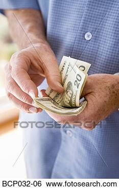 Stock Photo - man holding american 
currency. fotosearch 
- search stock 
photos, pictures, 
images, and photo 
clipart