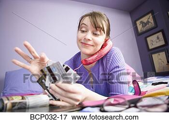 Picture - woman on the phone 
choosing credit 
card. fotosearch 
- search stock 
photos, pictures, 
images, and photo 
clipart