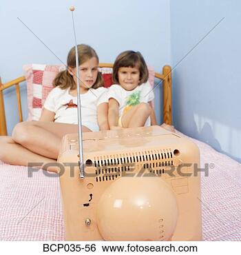 Stock Photo - girls watching 
television in 
bed. fotosearch 
- search stock 
photos, pictures, 
images, and photo 
clipart