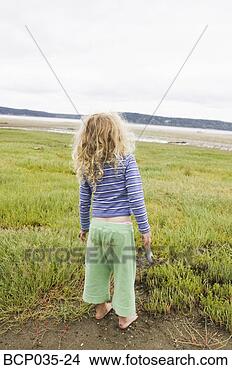 Stock Photo - young girl standing 
alone outdoors. 
fotosearch - search 
stock photos, 
pictures, images, 
and photo clipart
