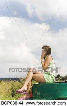 Stock Photo - woman sitting 
on car and talking 
on mobile phone. 
fotosearch - search 
stock photos, 
pictures, images, 
and photo clipart
