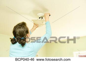 Stock Photo - woman repairing 
light fixture 
on ceiling. fotosearch 
- search stock 
photos, pictures, 
images, and photo 
clipart