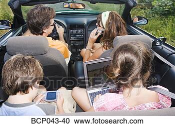 Stock Photography - family in convertible 
using portable 
electronics. fotosearch 
- search stock 
photos, pictures, 
images, and photo 
clipart