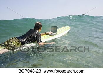 Stock Photo - man using laptop 
while surfing. 
fotosearch - search 
stock photos, 
pictures, images, 
and photo clipart