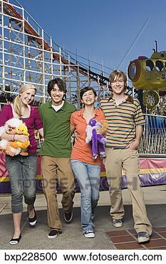 Stock Photography - teenagers walking 
through amusement 
park. fotosearch 
- search stock 
photos, pictures, 
images, and photo 
clipart