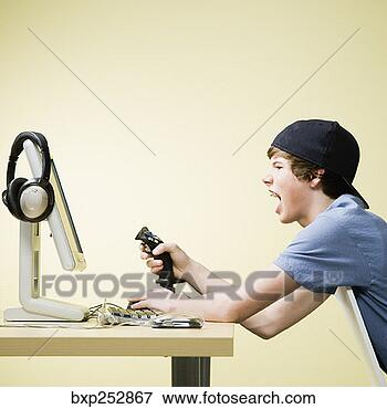 Picture - excited teenage 
boy playing videogame. 
fotosearch - search 
stock photos, 
pictures, images, 
and photo clipart