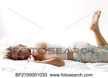 Stock Photo - a beautiful blonde 
woman lays in 
bed wearing casual 
pajamas. fotosearch 
- search stock 
photos, pictures, 
images, and photo 
clipart
