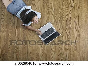 Stock Photography - high angle view 
of a teenage girl 
lying on the floor 
working on a. 
fotosearch - search 
stock photos, 
pictures, images, 
and photo clipart