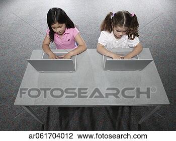 Stock Photo - high angle view 
of two young girls 
sitting in a classroom 
at school. fotosearch 
- search stock 
photos, pictures, 
images, and photo 
clipart