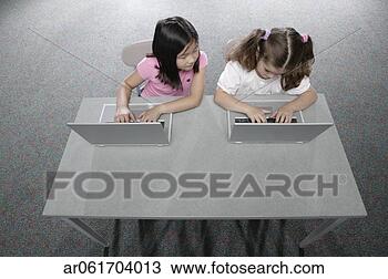 Stock Photo - high angle view 
of two young girls 
sitting in a classroom 
at school. fotosearch 
- search stock 
photos, pictures, 
images, and photo 
clipart