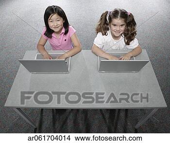Stock Photo - high angle view 
of two young girls 
sitting in a classroom 
at school. fotosearch 
- search stock 
photos, pictures, 
images, and photo 
clipart