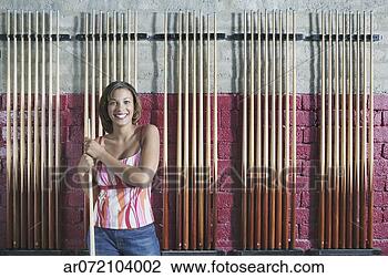 Stock Photo - portrait of a 
woman standing 
holding a cue 
stick in front 
of a wall. fotosearch 
- search stock 
photos, pictures, 
images, and photo 
clipart