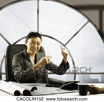 Stock Photo - portrait of a 
young businesswoman 
sitting behind 
an office desk. 
fotosearch - search 
stock photos, 
pictures, images, 
and photo clipart