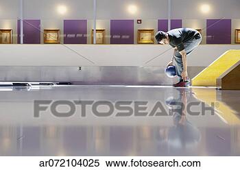 Stock Image - side profile of 
a young man bowling 
in a bowling alley. 
fotosearch - search 
stock photos, 
pictures, images, 
and photo clipart