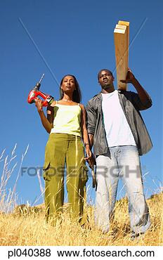 Stock Photo - young couple standing 
holding planks 
of wood and a 
drill machine. 
fotosearch - search 
stock photos, 
pictures, images, 
and photo clipart
