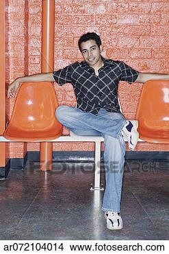 Stock Photo - young man sitting 
on orange chairs. 
fotosearch - search 
stock photos, 
pictures, images, 
and photo clipart
