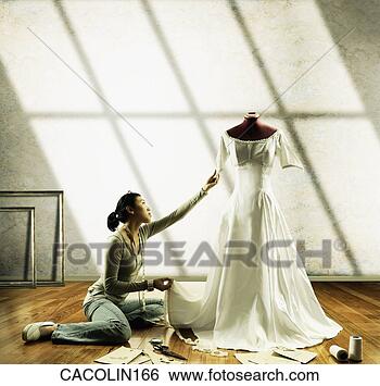 Stock Photo - young seamstress 
working on a wedding 
gown on a mannequin. 
fotosearch - search 
stock photos, 
pictures, images, 
and photo clipart