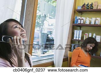 Picture - young woman smiling 
talking on a mobile 
phone with a young 
woman. fotosearch 
- search stock 
photos, pictures, 
images, and photo 
clipart