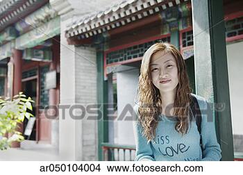 Stock Photo - young woman standing 
outdoors looking 
at camera smiling, 
 beijing. fotosearch 
- search stock 
photos, pictures, 
images, and photo 
clipart