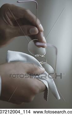 Stock Photo - close-up of a 
person wiping 
their eye glasses 
with a piece of 
cloth. fotosearch 
- search stock 
photos, pictures, 
images, and photo 
clipart