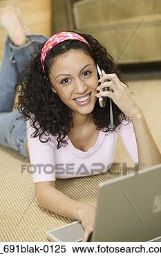 Stock Image - high angle view 
of a young woman 
lying on the floor 
in front of a. 
fotosearch - search 
stock photos, 
pictures, images, 
and photo clipart