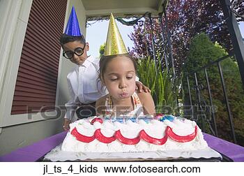 Stock Photo - low angle view 
of a young girl 
blowing out birthday 
candles with a. 
fotosearch - search 
stock photos, 
pictures, images, 
and photo clipart