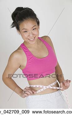 Stock Photograph - portrait of a 
teenage girl measuring 
her waist. fotosearch 
- search stock 
photos, pictures, 
images, and photo 
clipart